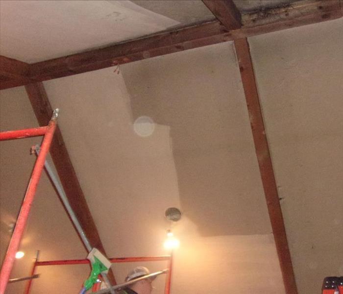 A ceiling after a heavy soot fire in the process of being cleaned.